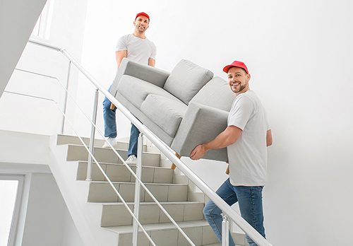 Loaders carrying furniture in the stairway
